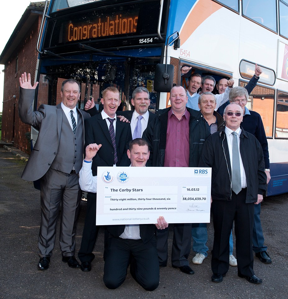 a group of men holding a cheque that says the corby stars