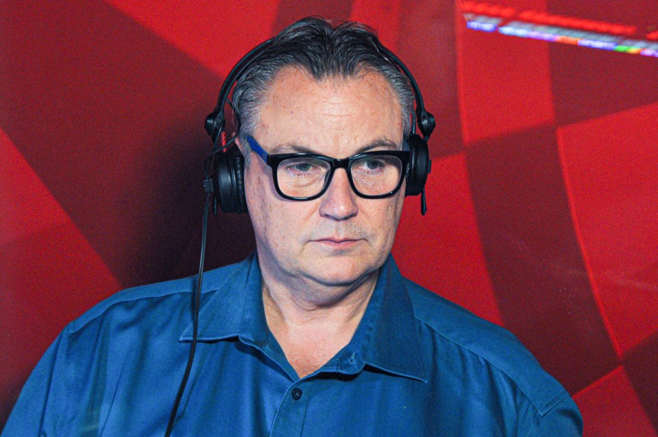 a man wearing glasses and headphones looks at the camera