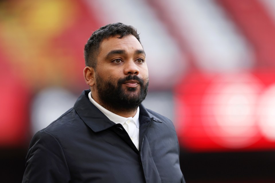 a man with a beard wearing a black jacket and white shirt