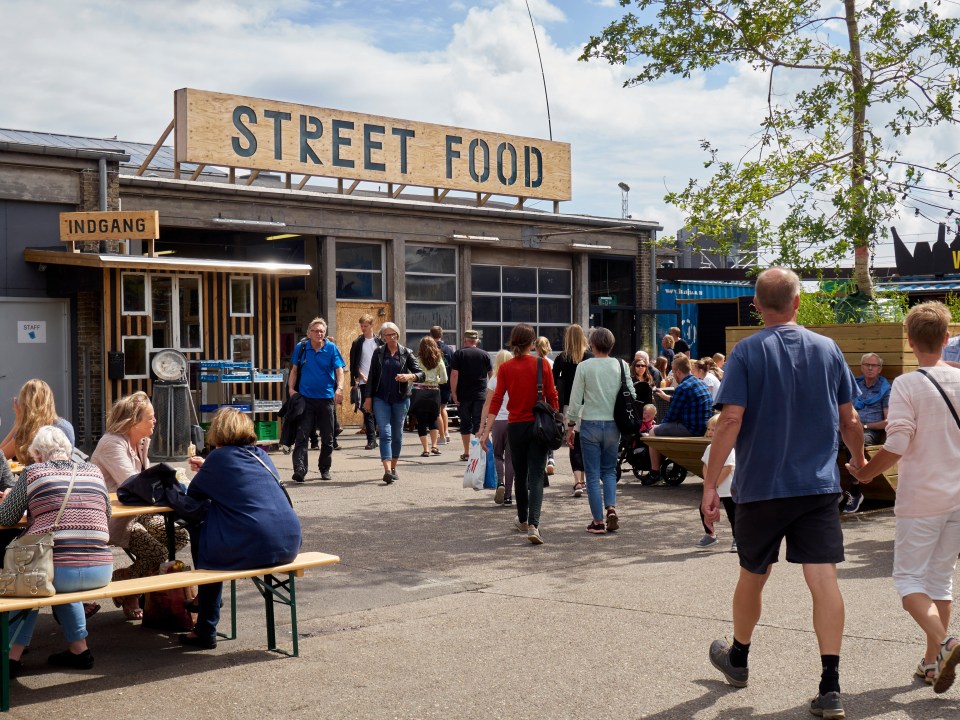 people walking in front of a building that says street food