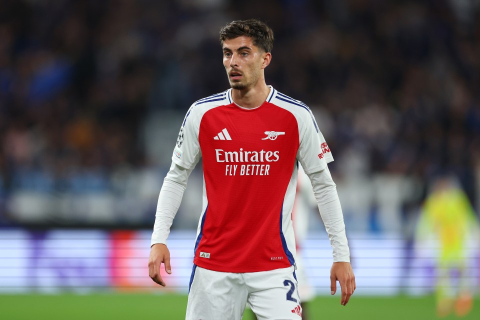 a soccer player wearing a red emirates fly better jersey