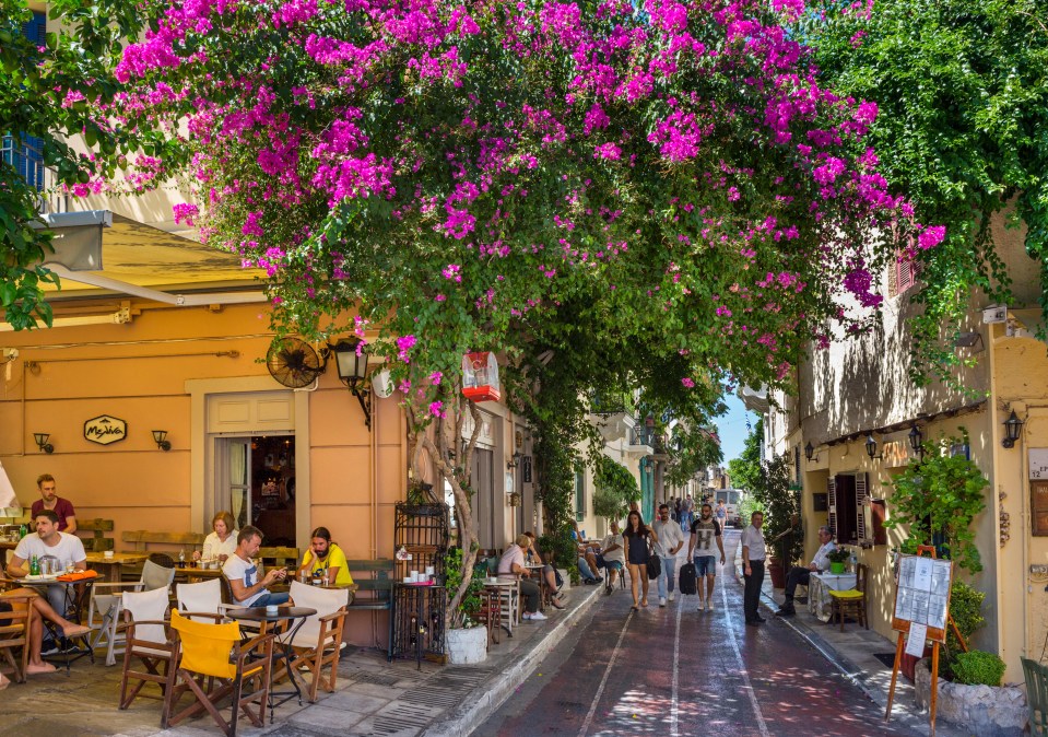 people sit at tables outside a restaurant called mykola