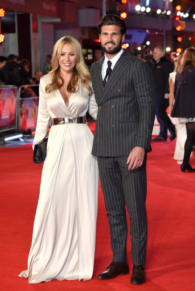 a man and woman are posing for a picture on a red carpet