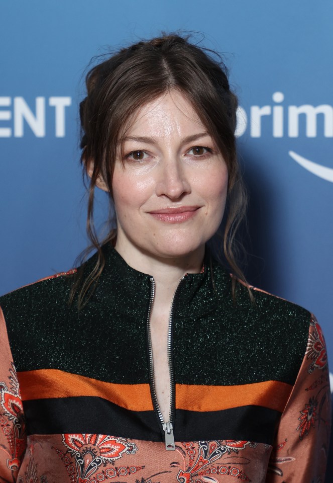 a woman stands in front of a blue background with the word ent on it