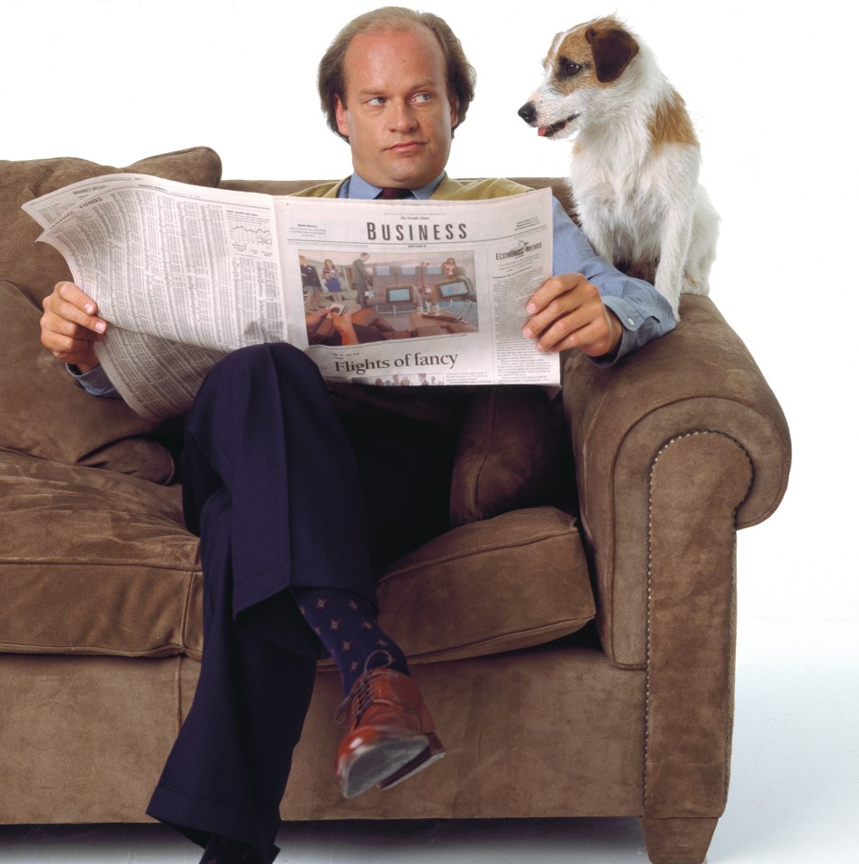 a man sits on a couch reading a business newspaper