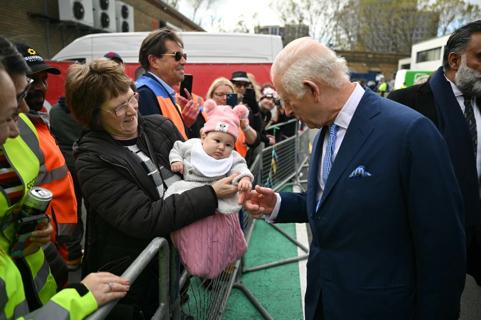 Charles greeted a baby in the crowds