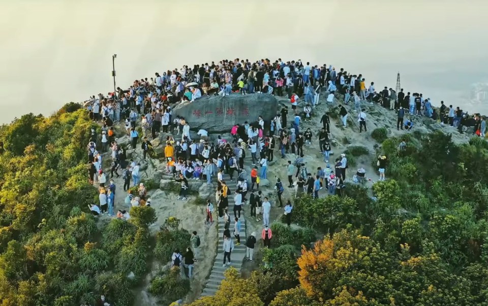 a large group of people are gathered on top of a mountain