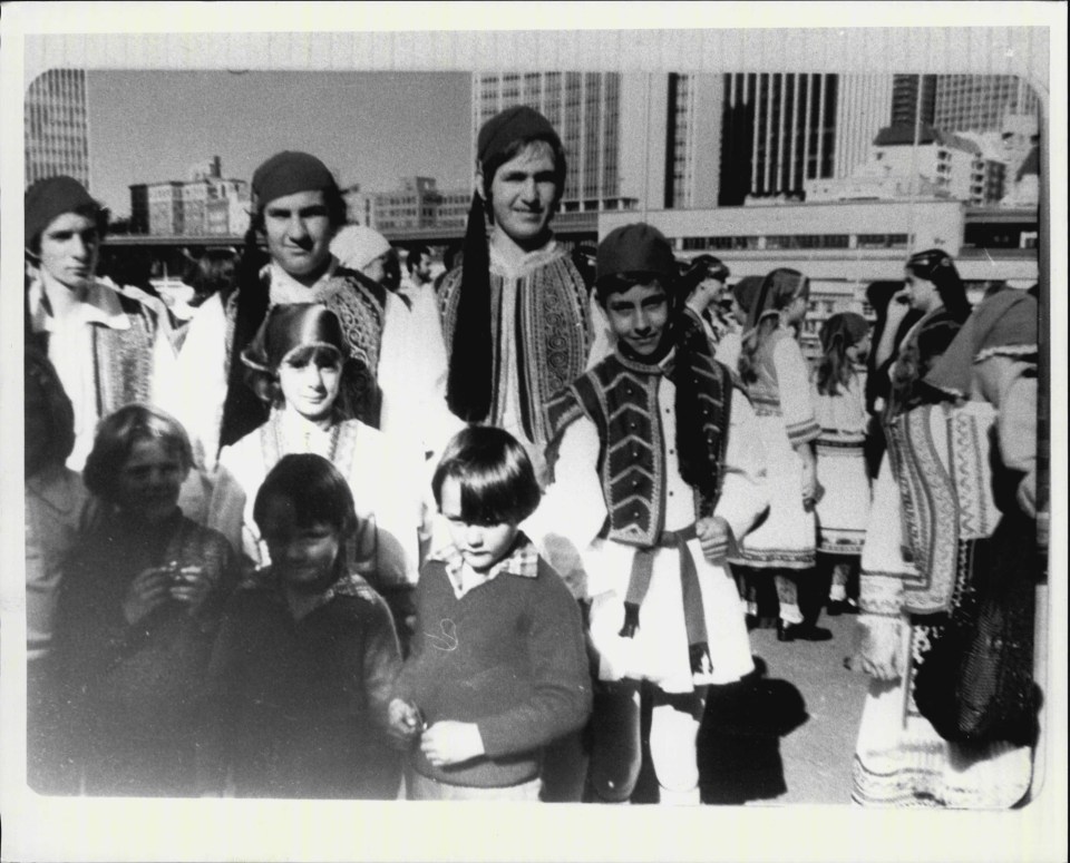 a black and white photo of a group of people with one wearing a sweater with the letter s on it