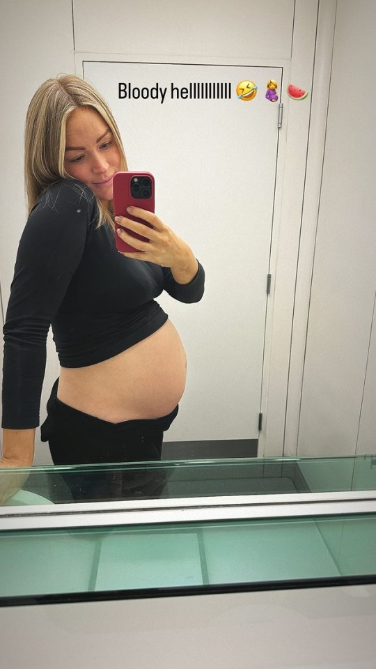 a pregnant woman is taking a picture of her belly in front of a mirror