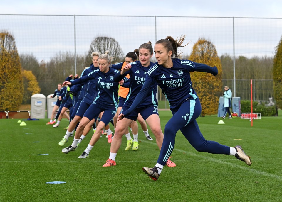 a group of female soccer players wearing emirates fly better uniforms