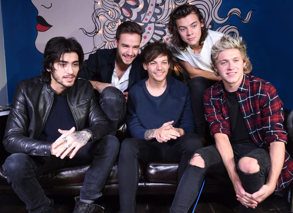 a group of young men sitting on a couch posing for a picture