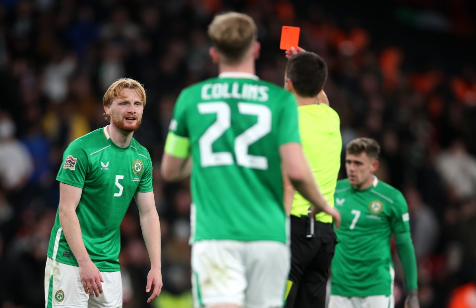 a referee gives a red card to a soccer player wearing number 14