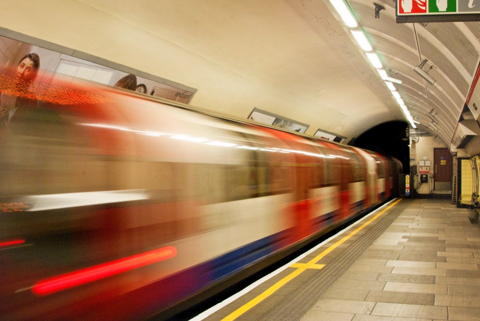 a red and white train is pulling into a subway station