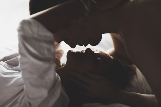 a man and a woman are kissing in a dark room