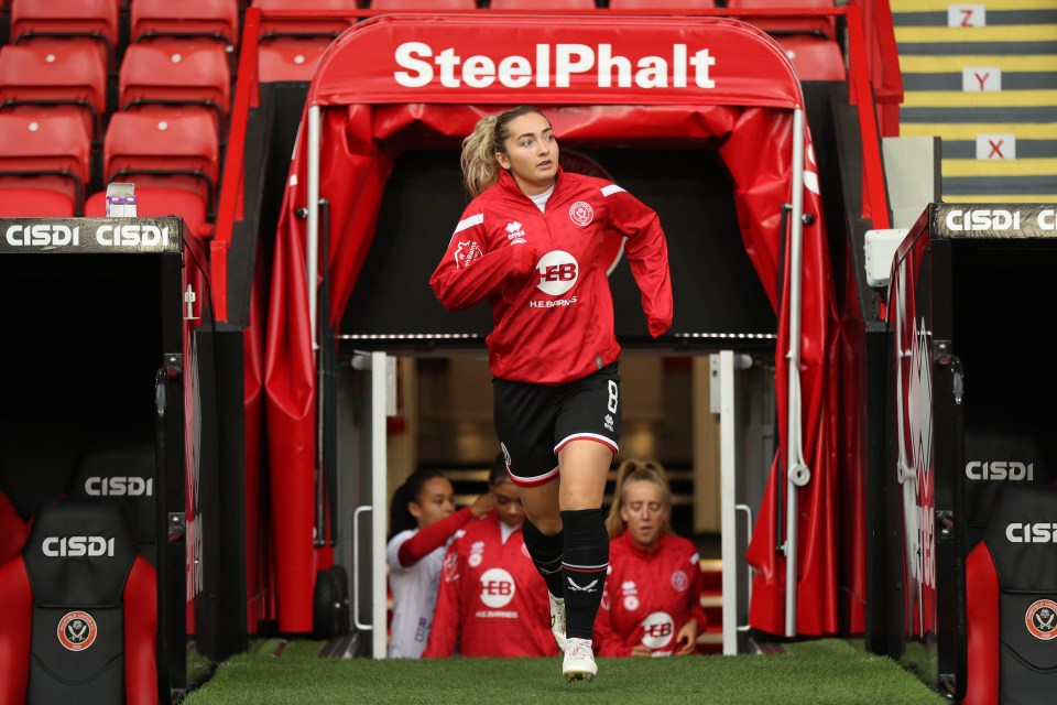 a female soccer player walks out of a steelphalt tunnel