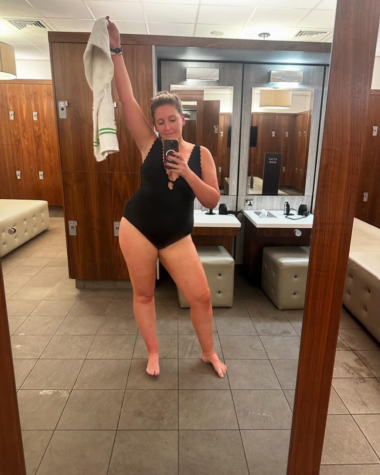 a woman taking a picture of herself in a locker room