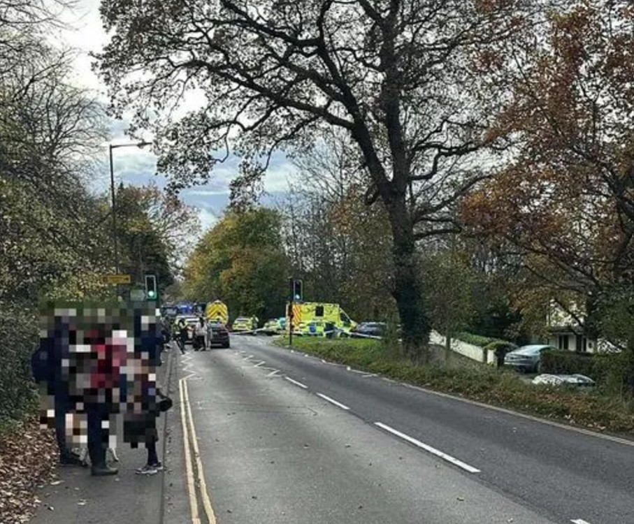 a group of people are standing on the side of a road next to an ambulance .