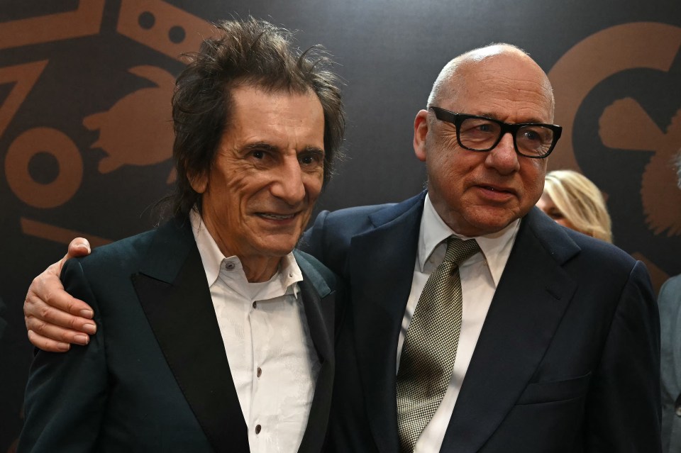 Musicians Ronnie Wood (L) and Mark Knopfler greeted each other