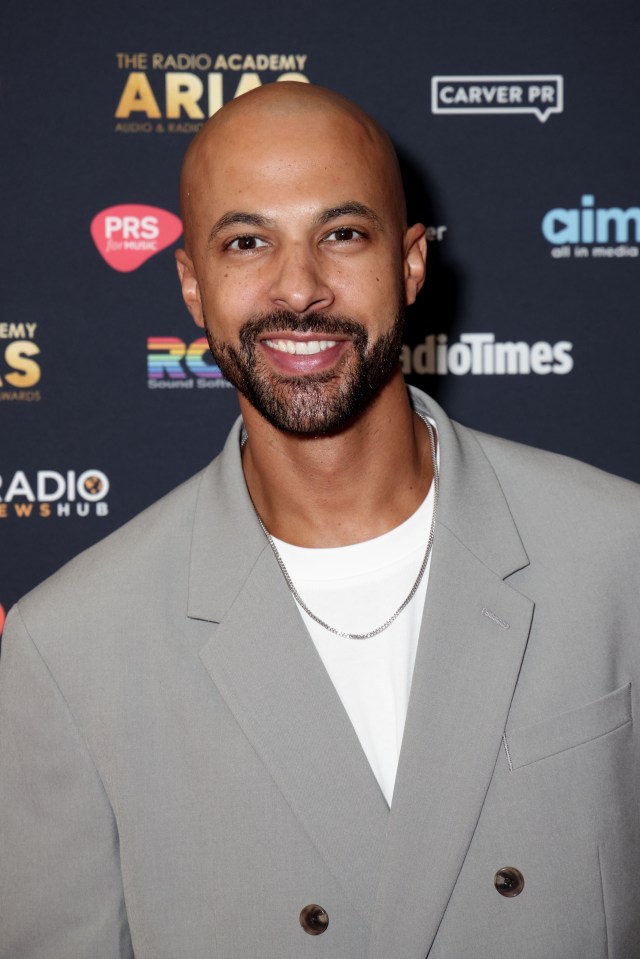 a bald man with a beard is smiling in front of a blue background that says the radio academy