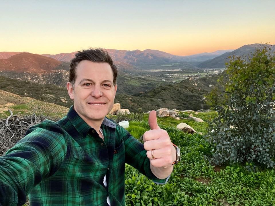 a man in a plaid shirt is giving a thumbs up