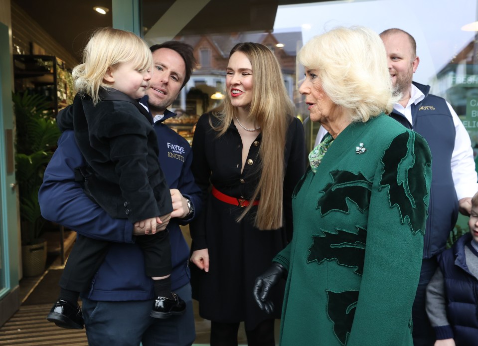 a woman in a green coat is talking to a group of people