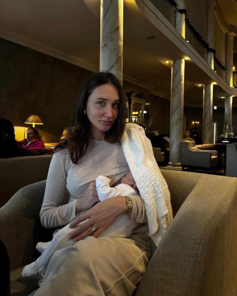 a woman is breastfeeding a baby in a chair