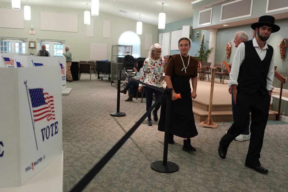 people walking in a room with a sign that says vote