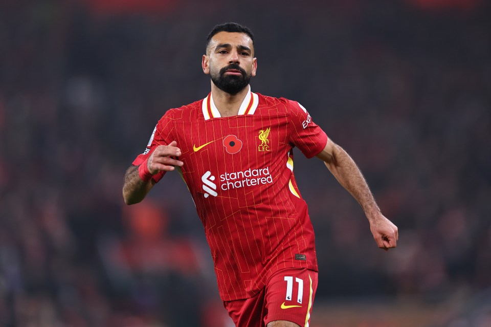 a soccer player wearing a red jersey that says standard chartered