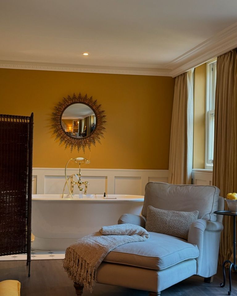 The open plan bedroom features a freestanding bath tub