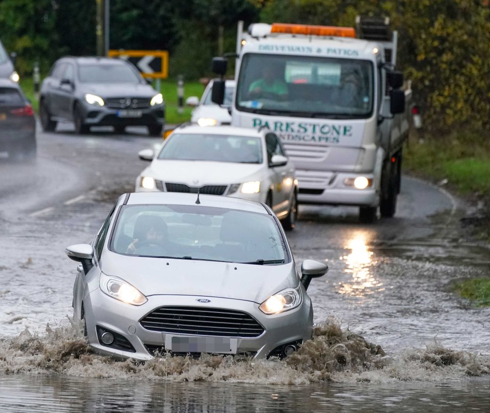 Motorists drive through flooded roads in Brentwood Essex