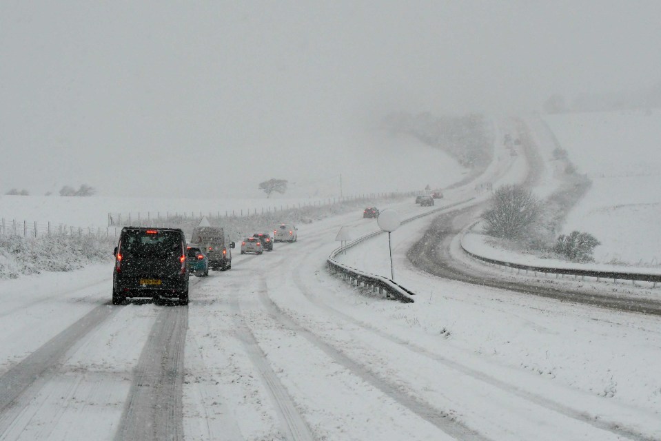 cars are driving down a snowy road and one of them has a license plate that says yj32