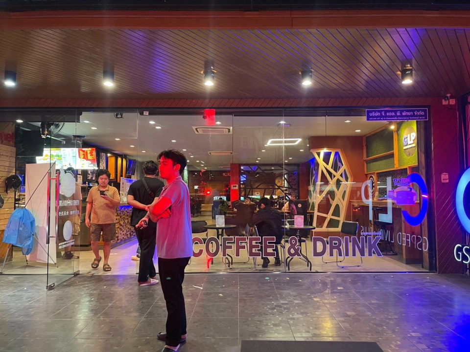 a man standing in front of a coffee and drink store