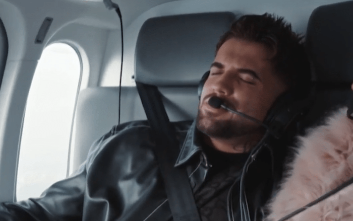 a man wearing headphones is sleeping on a plane