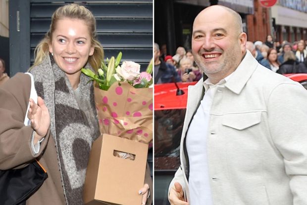 a woman holding a box of flowers next to a man