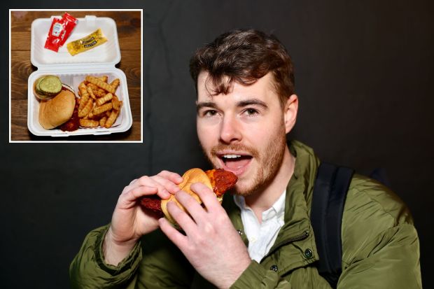 a man is eating a sandwich next to a box of ketchup and mustard