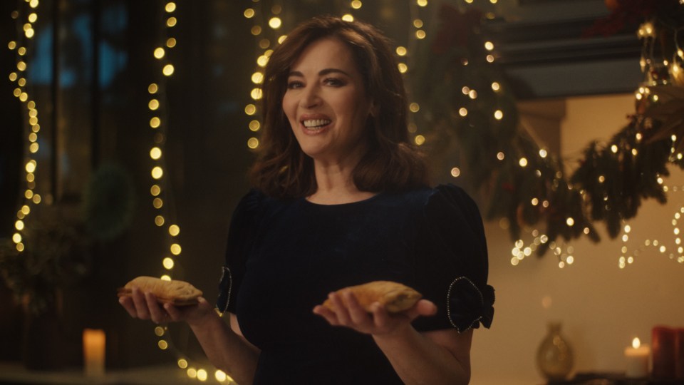 a woman in a blue dress is holding two pastries in her hands