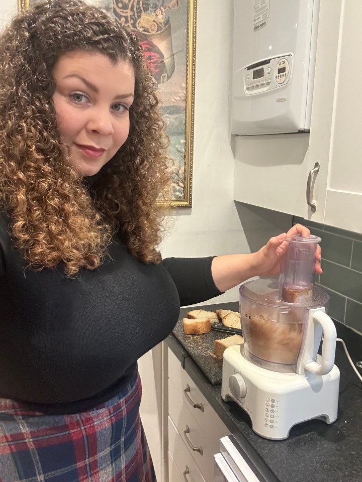 a woman is using a food processor in a kitchen