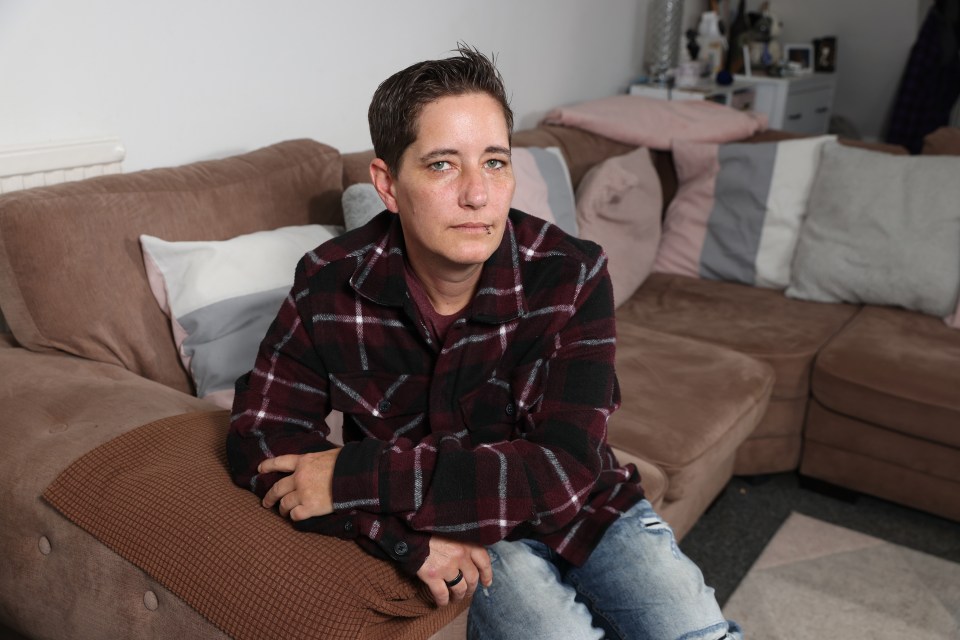 a woman in a plaid shirt sits on a couch