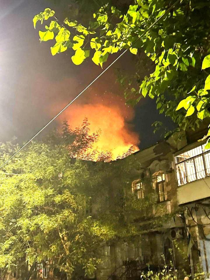 A  large fire engulfs the roof of a residential building during the night aftermath of a Russian large-scale drone attack on Odesa