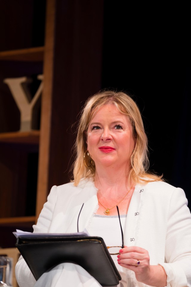 a woman sitting in front of a bookshelf with the letter y on it