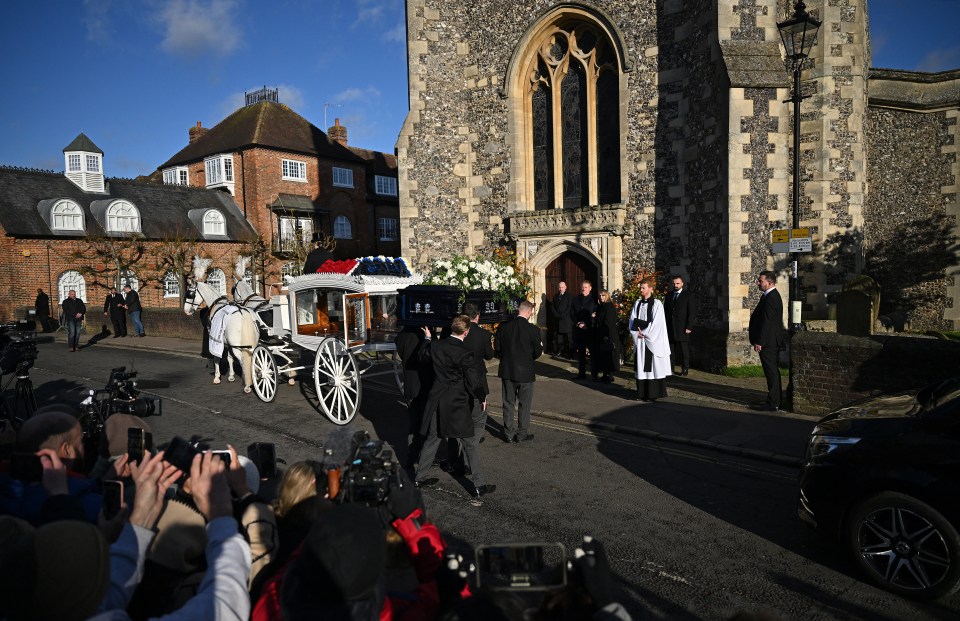 a horse drawn carriage carrying a casket with the word r.i.p. on it