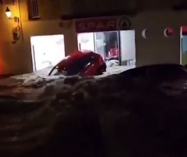 A car is steadily submerged in the floodwater overnight