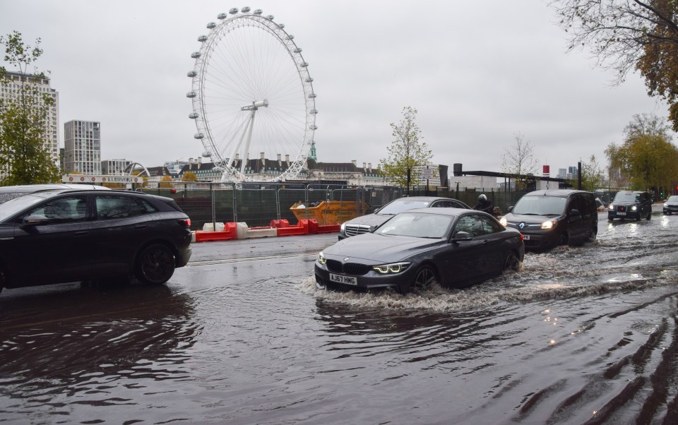 People walk along a waterlogged Victoria Embankment