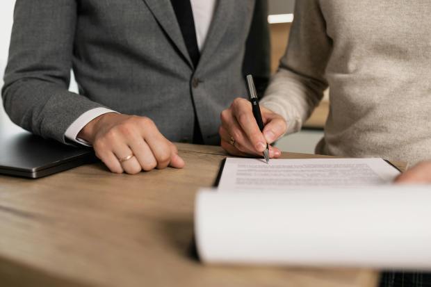 a man and a woman are signing a document