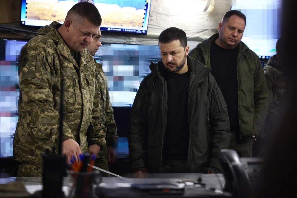 a group of men in military uniforms are looking at something