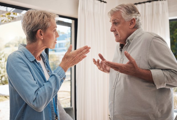 a man and a woman are having an argument in front of a window