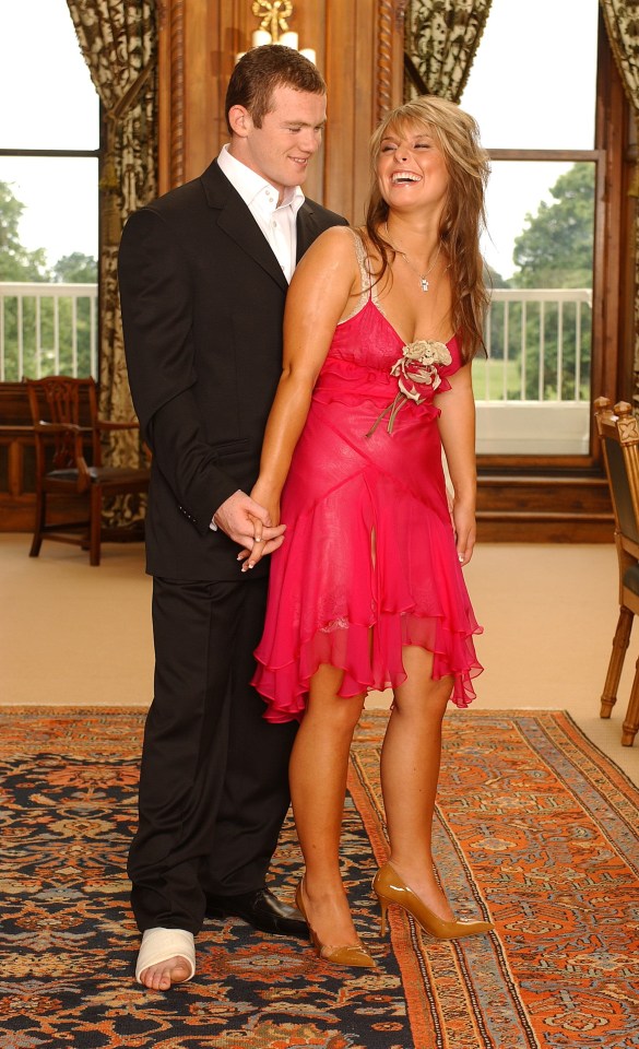 a man in a suit stands next to a woman in a pink dress