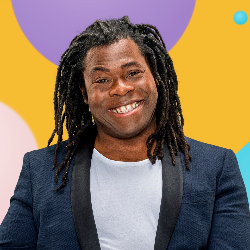 a man with dreadlocks is smiling in front of a colorful background