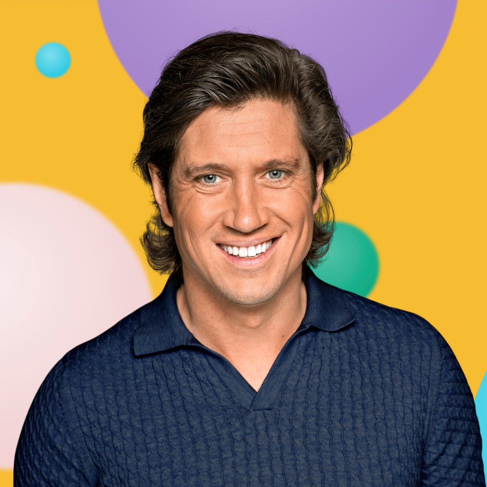 a man in a blue shirt is smiling in front of a colorful background