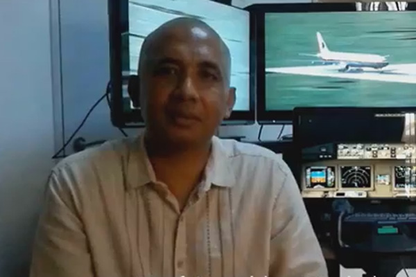 a man sitting in front of a monitor with a plane on it